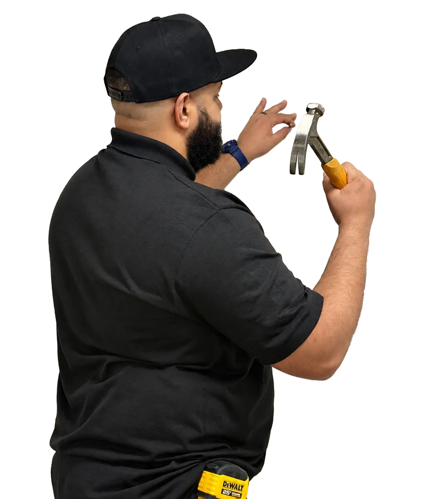 Osvaldo hammering a nail into the wall